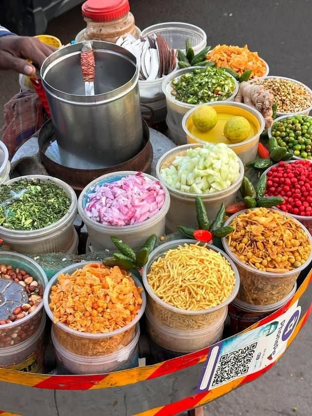 A chaat cart laid out with bowls of toppings and chutneys